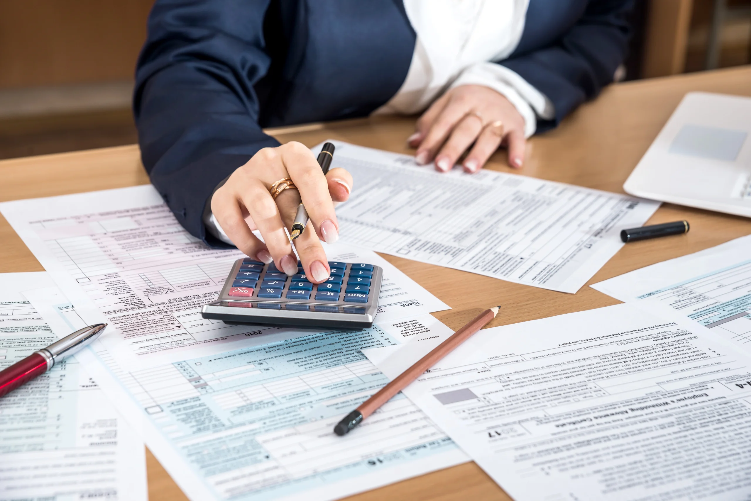 Un conseiller retraite effectue le calcul des 25 meilleures années de carrière d’une cliente à l’aide d’une calculatrice.