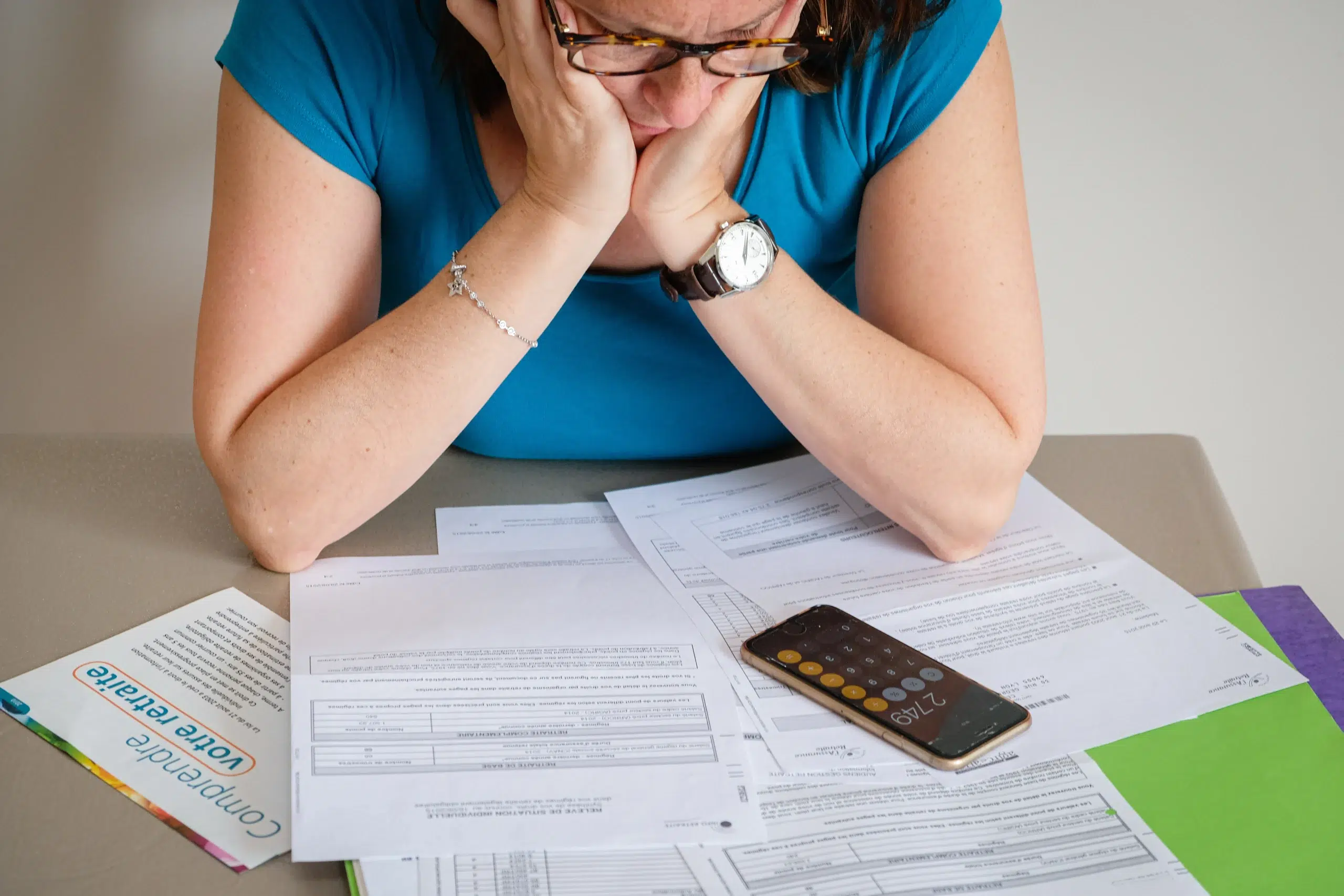 Une future retraitée calcule son épargne avec une calculatrice pour choisir entre rente viagère et capital