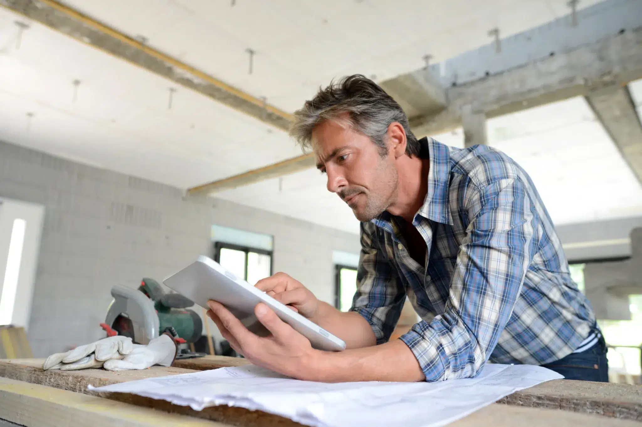 Artisan sur un chantier consultant un plan de construction – retraite des indépendants, artisans et commerçants : règles, calcul, âge de départ et optimisation