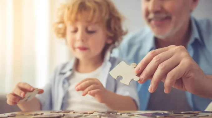 Grand-père Retraité Jouant Au Puzzle Avec Son Petit-fils – Illustration Des Majorations Enfants Dans La Retraite Agirc-Arrco