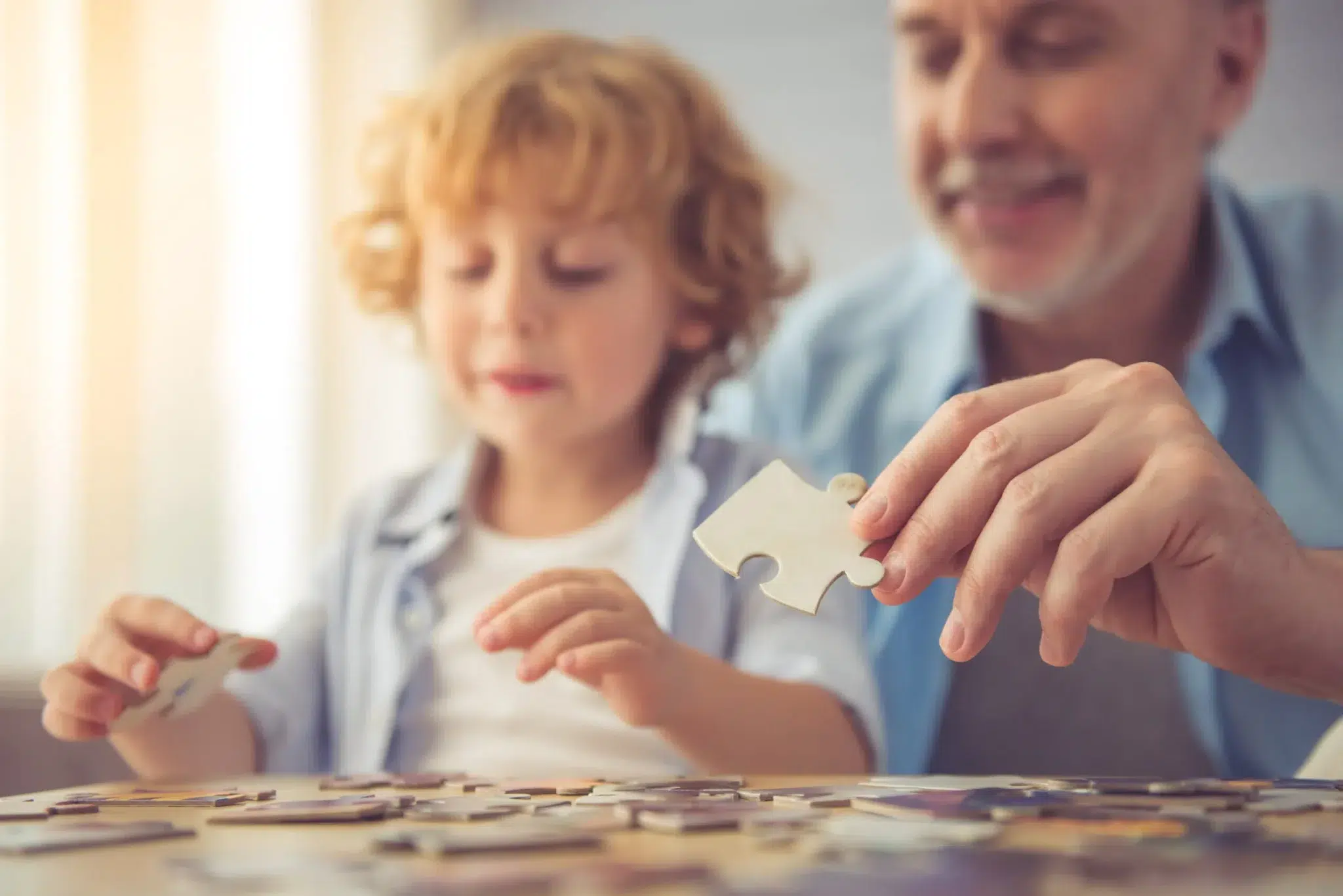 Grand-père retraité jouant au puzzle avec son petit-fils – illustration des majorations enfants dans la retraite Agirc-Arrco