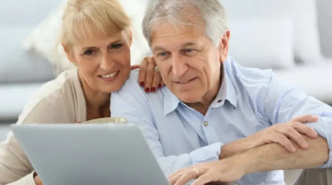 Couple Consultant Leur éligibilité Au Départ Anticipé Pour Carrière Longue Sur Un Ordinateur.