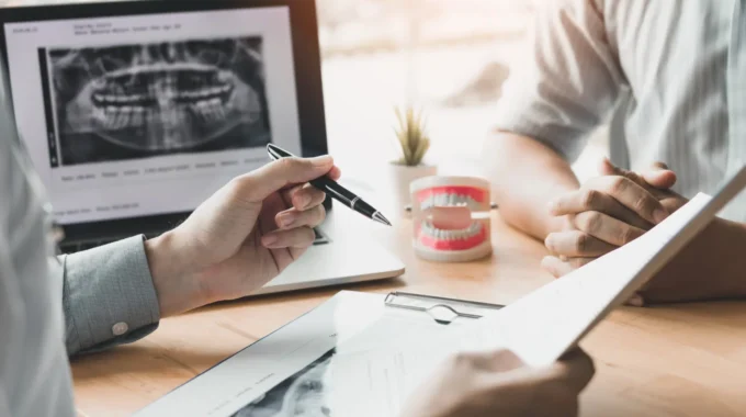 Chirurgien-dentiste Expliquant Un Devis à Son Patient, Illustrant La Préparation Financière Et Le Calcul De La Retraite CARCDSF