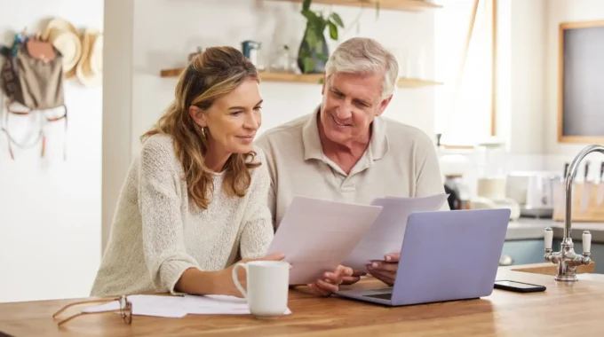 Couple D’entrepreneurs Travaillant Sur La Retraite Du Conjoint Collaborateur Devant Un Ordinateur Dans Leur Cuisine