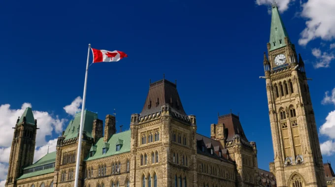 Parlement Du Canada à Ottawa Avec Un Drapeau Canadien Flottant – Symbole Du Système De Retraite Canadien Et De La Coordination France–Canada