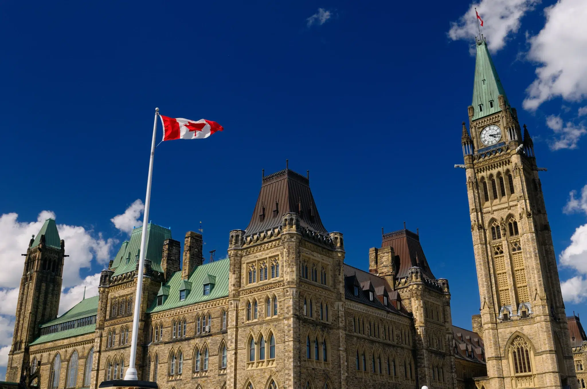 Parlement du Canada à Ottawa avec un drapeau canadien flottant – symbole du système de retraite canadien et de la coordination France–Canada