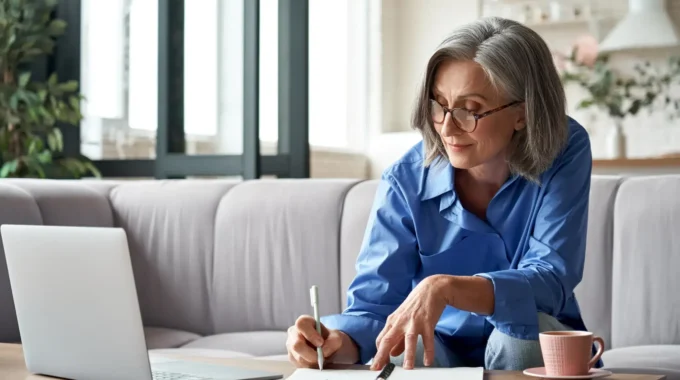 Femme Senior Prenant Des Notes Devant Son Ordinateur Pour évaluer L'impact D'un Congé De Reclassement Sur Sa Retraite